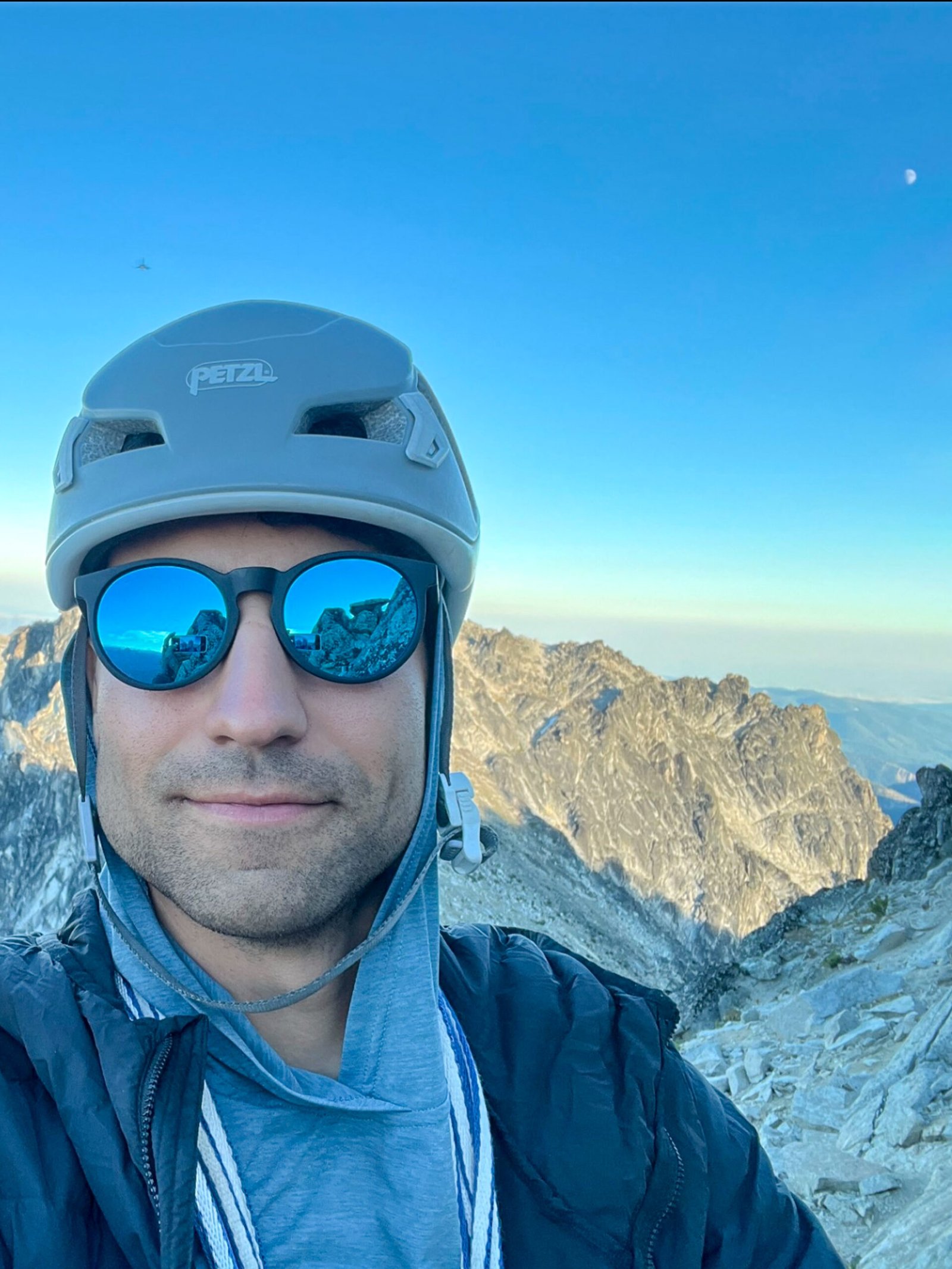 Ceasar Gutierrez, sales specialist at Optimum Adventures, taking a summit selfie on Dragontail Peak in Washington’s Enchantments during a mountain adventure.