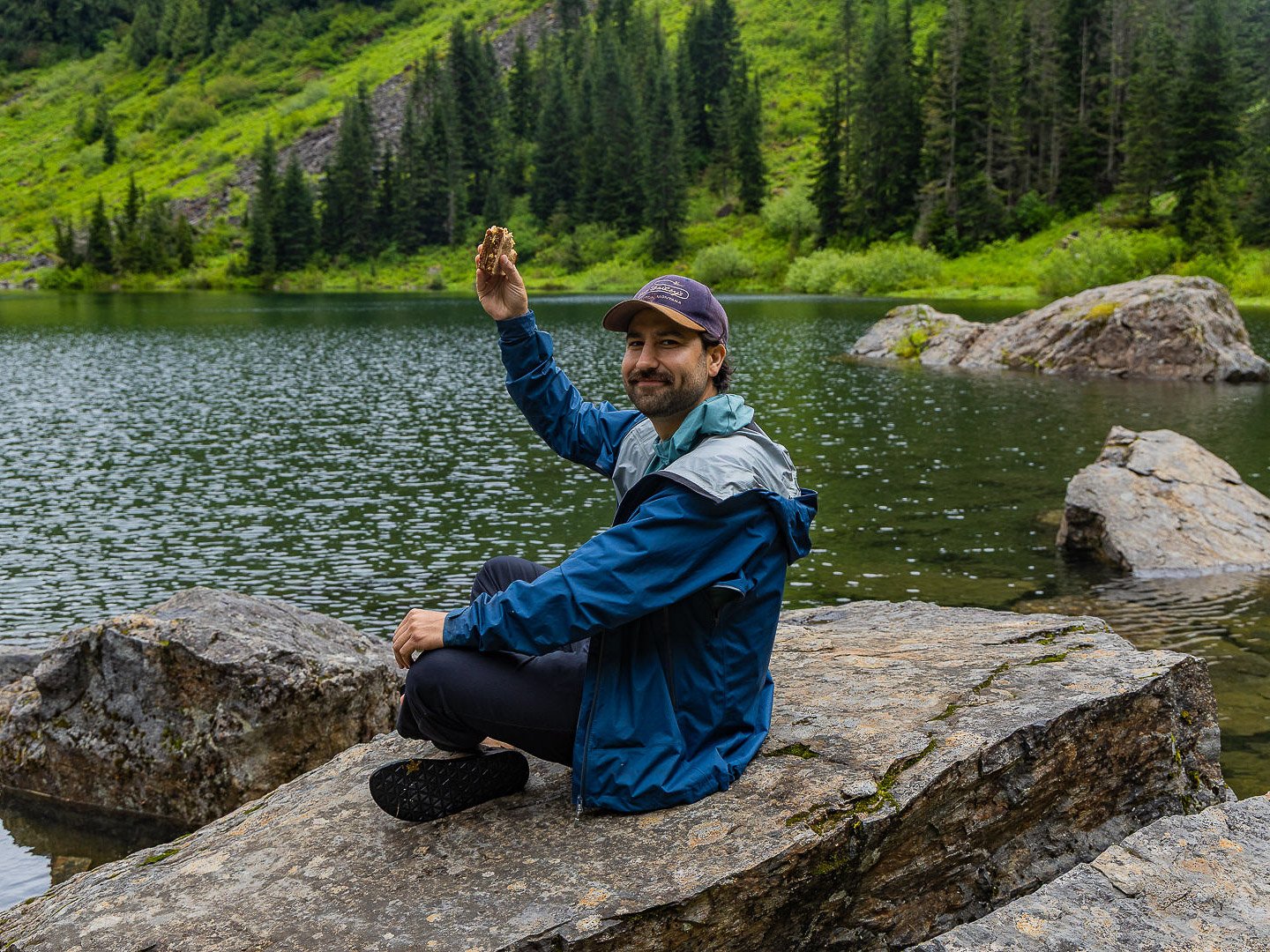A guest enjoying a fresh sandwich before paddling during the Optimum Adventures Lake 22 tour, combining hiking, lunch, and alpine lake kayaking in Washington.