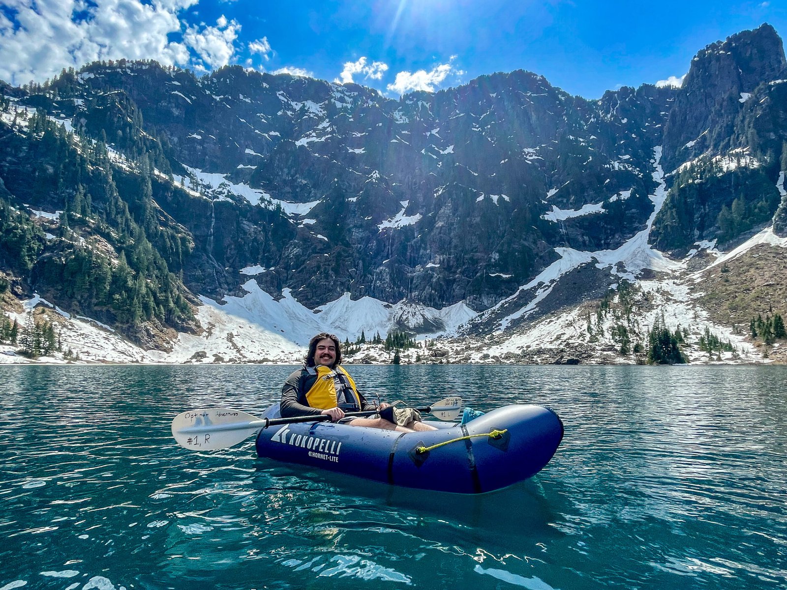A guest paddling on Lake 22 beneath its towering mountain backdrop during the Optimum Adventures Lake 22 kayaking tour in Washington.