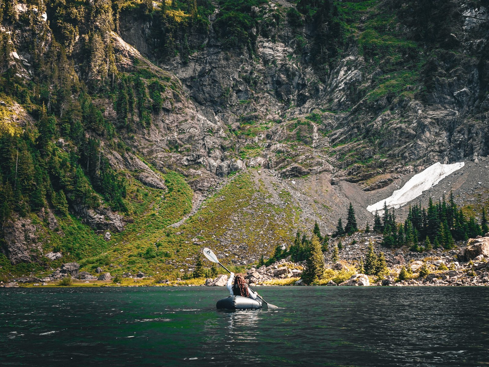 A guest paddling a Kokopelli Hornet-Lite packraft into Lake 22 during the Optimum Adventures Lake 22 kayaking tour in Washington.